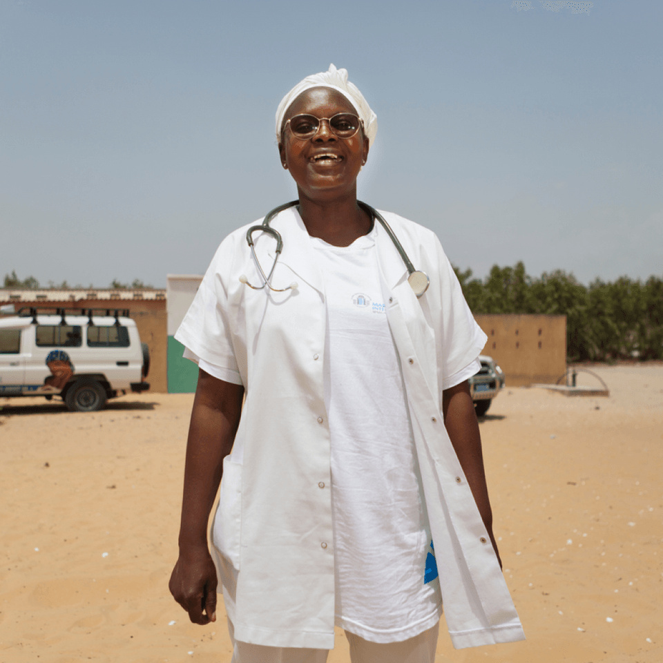 Portrait of a smiling woman healthcare worker with white coat and stethoscope.